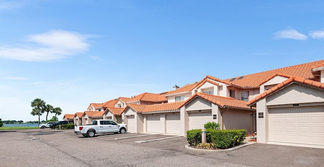 703 Magnolia Pl Unit 703, Winter Haven, FL 33884 - view of front of home with community garages, stucco siding, a residential view, and a tile roof