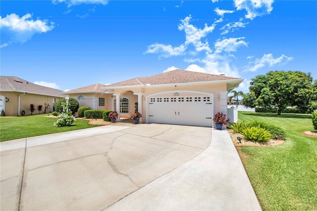 413 Ruby Lake Pl, Winter Haven, FL 33884 - mediterranean / spanish house with a front yard, stucco siding, a garage, and concrete driveway