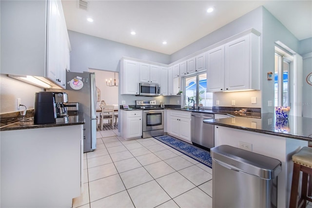 413 Ruby Lake Pl, Winter Haven, FL 33884 - kitchen with stainless steel appliances, a peninsula, white cabinets, light tile patterned floors, and recessed lighting