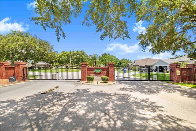 413 Ruby Lake Pl, Winter Haven, FL 33884 - view of asphalt road with a gate, street lights, a gated entry, and curbs