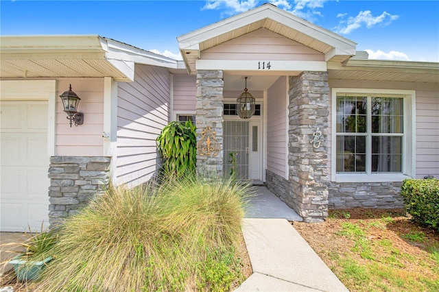 114 Belmont Dr, Winter Haven, FL 33884 - doorway to property featuring stone siding and an attached garage