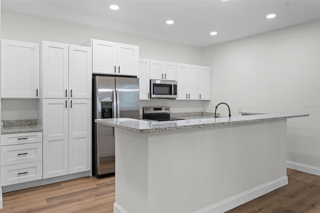 2052 W Elliott St, Lakeland, FL 33805 - kitchen featuring stainless steel appliances, light wood-type flooring, white cabinets, a sink, and recessed lighting