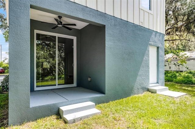 2052 W Elliott St, Lakeland, FL 33805 - view of exterior entry featuring ceiling fan, board and batten siding, and stucco siding