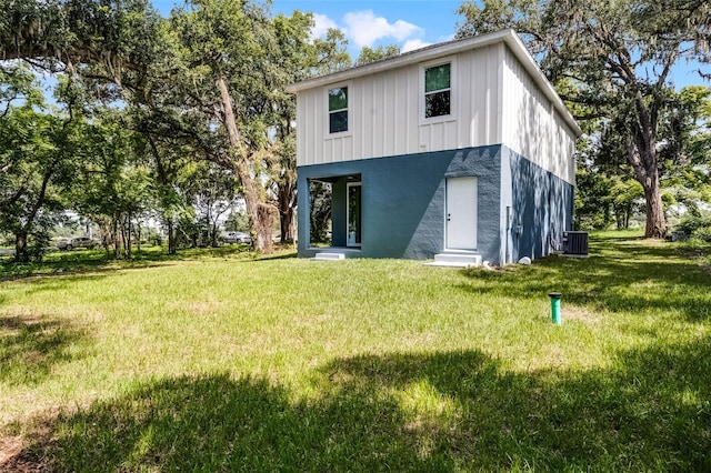 2052 W Elliott St, Lakeland, FL 33805 - back of property featuring central air condition unit, a lawn, board and batten siding, and entry steps
