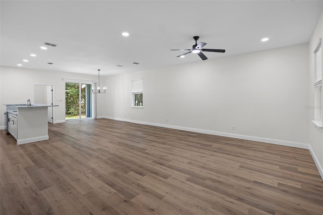 2052 W Elliott St, Lakeland, FL 33805 - unfurnished living room with dark wood-style floors, baseboards, a chandelier, and recessed lighting