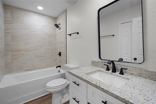 2052 W Elliott St, Lakeland, FL 33805 - full bathroom with vanity, toilet, wood finished floors, shower / bath combination, and a textured wall