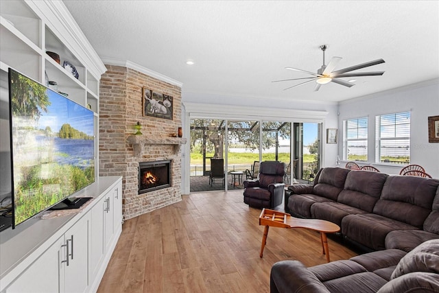 505 Adams View Ln, Auburndale, FL 33823 - living area featuring ceiling fan, a fireplace, light wood-style flooring, and crown molding