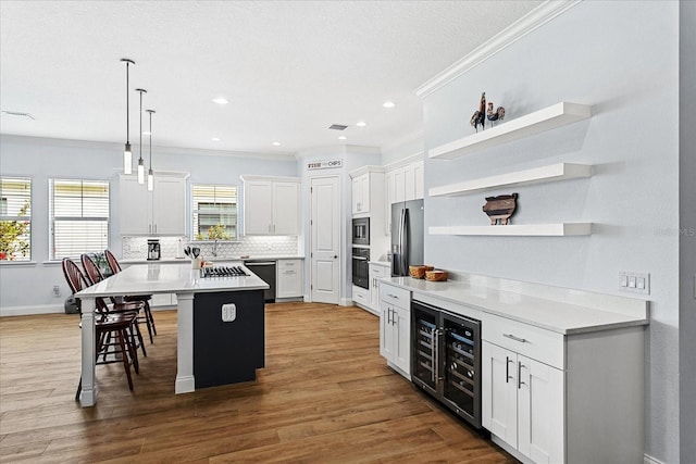 505 Adams View Ln, Auburndale, FL 33823 - kitchen featuring open shelves, beverage cooler, ornamental molding, stainless steel appliances, and a center island