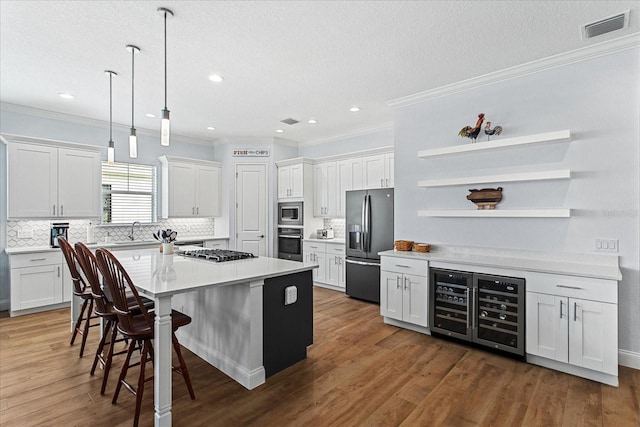 505 Adams View Ln, Auburndale, FL 33823 - kitchen with stainless steel appliances, beverage cooler, open shelves, crown molding, and a center island