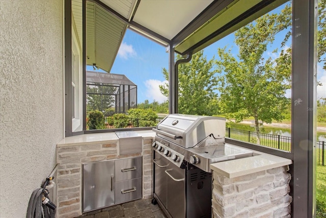 505 Adams View Ln, Auburndale, FL 33823 - view of patio featuring an outdoor kitchen, a water view, and glass enclosure