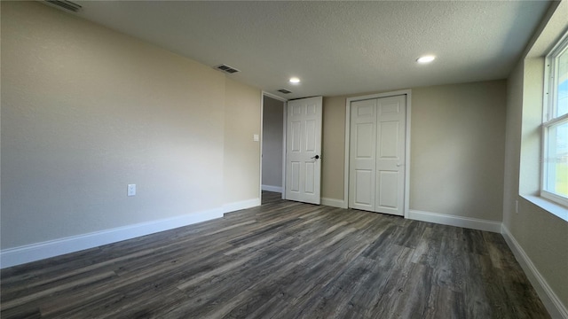 1735 Council Dr, Sun City Center, FL 33573 - unfurnished bedroom with dark wood-style flooring, a textured ceiling, recessed lighting, a closet, and baseboards
