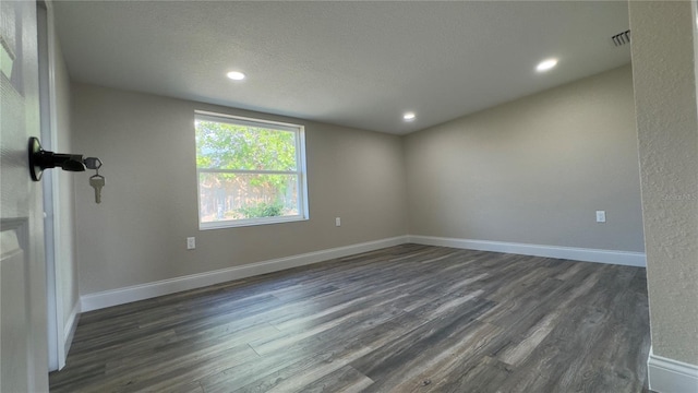 1735 Council Dr, Sun City Center, FL 33573 - empty room with dark wood-type flooring, baseboards, recessed lighting, and a textured ceiling