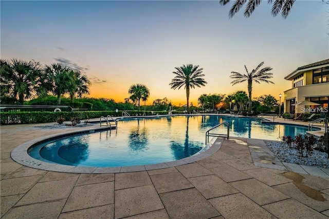 1735 Council Dr, Sun City Center, FL 33573 - pool at dusk with a community pool and a patio area