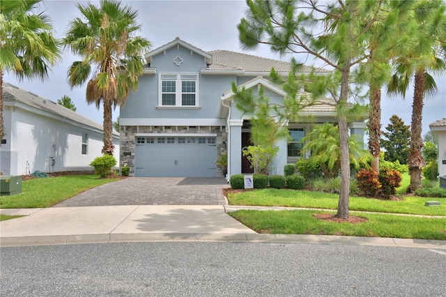 1433 Bunker Dr, Davenport, FL 33896 - view of front facade with stone siding, a garage, driveway, a front lawn, and stucco siding