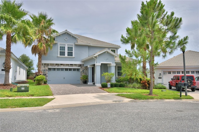 1433 Bunker Dr, Davenport, FL 33896 - view of front of property with driveway, stone siding, an attached garage, stucco siding, and a front yard