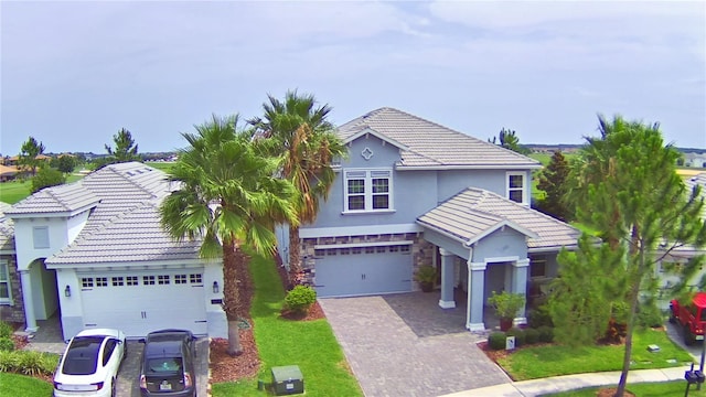 1433 Bunker Dr, Davenport, FL 33896 - traditional-style home with stucco siding, driveway, a tile roof, and stone siding