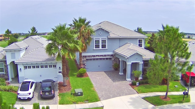 1433 Bunker Dr, Davenport, FL 33896 - traditional-style home featuring decorative driveway, a tiled roof, stucco siding, and stone siding