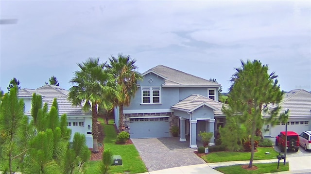 1433 Bunker Dr, Davenport, FL 33896 - traditional-style house with driveway, stucco siding, stone siding, a garage, and a tile roof