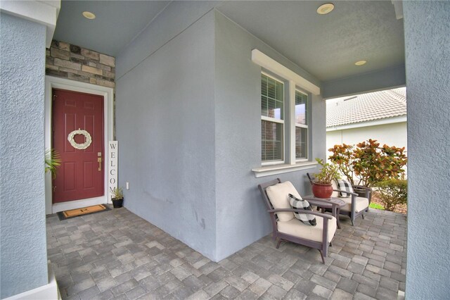 1433 Bunker Dr, Davenport, FL 33896 - view of exterior entry featuring stone siding, stucco siding, and a porch