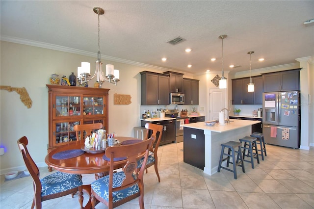 1433 Bunker Dr, Davenport, FL 33896 - kitchen featuring stainless steel appliances, light countertops, ornamental molding, a chandelier, and an island with sink