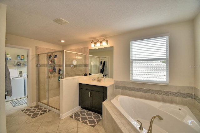 1433 Bunker Dr, Davenport, FL 33896 - bathroom with vanity, a garden tub, a stall shower, separate washer and dryer, and tile patterned flooring