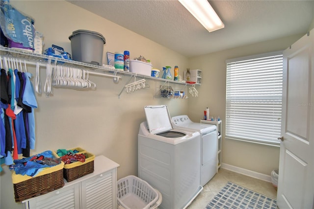 1433 Bunker Dr, Davenport, FL 33896 - laundry room featuring washer and clothes dryer, light tile patterned floors, a textured ceiling, and baseboards