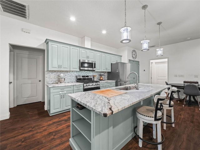 7714 Chase Rd, Lakeland, FL 33810 - kitchen with stainless steel appliances, a center island with sink, dark wood-style floors, a breakfast bar area, and recessed lighting