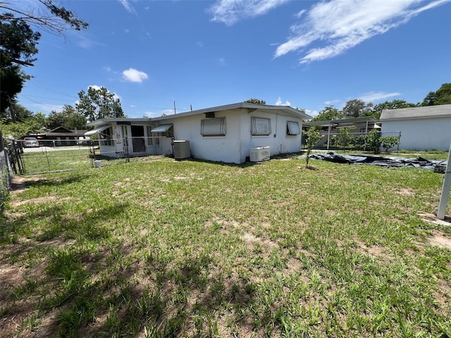 507 Ave H SE, Winter Haven, FL 33880 - back of property with central AC, stucco siding, and a gate