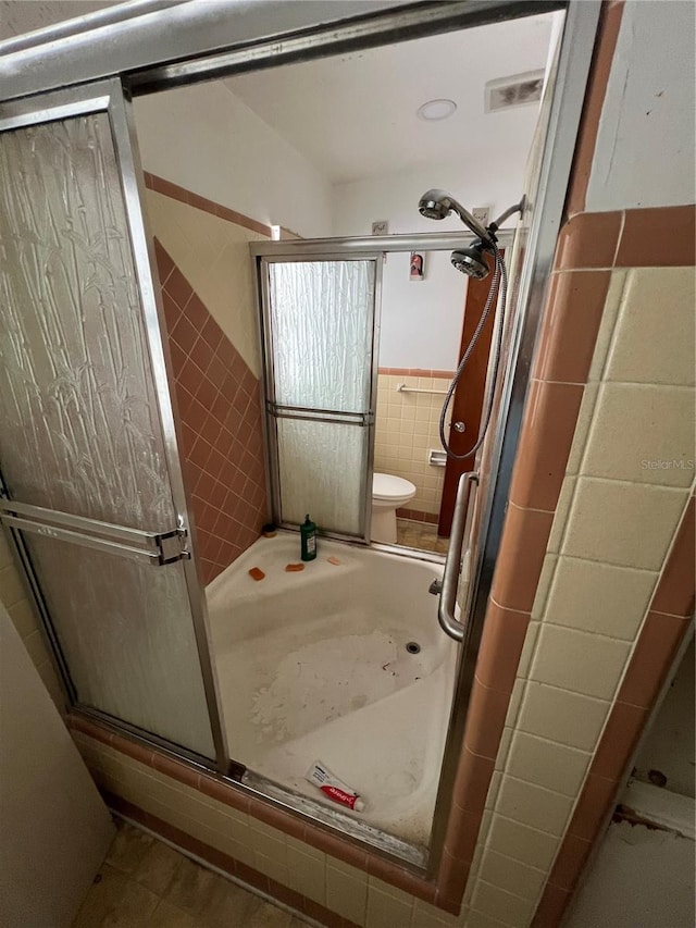 507 Ave H SE, Winter Haven, FL 33880 - full bath featuring a stall shower, tile walls, and toilet