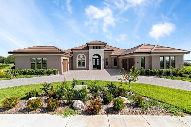 209 Pine Lilly Ct, Lake Alfred, FL 33850 - view of front of property with a garage, decorative driveway, stucco siding, and french doors