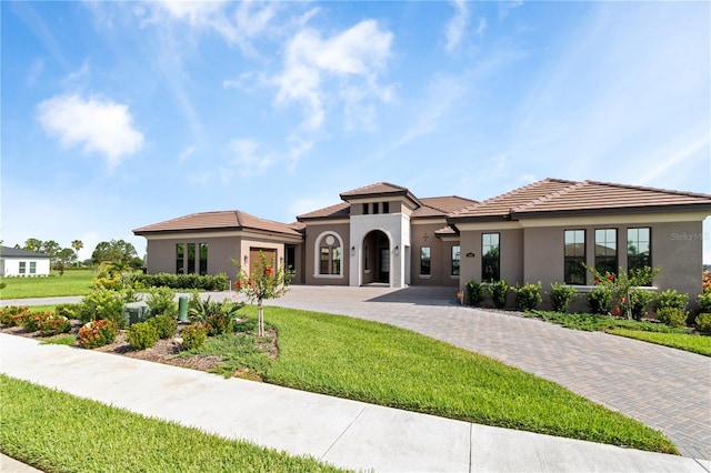 209 Pine Lilly Ct, Lake Alfred, FL 33850 - mediterranean / spanish-style home with driveway, a garage, a front yard, and stucco siding