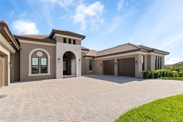 209 Pine Lilly Ct, Lake Alfred, FL 33850 - mediterranean / spanish-style home with a garage, stucco siding, decorative driveway, and a tiled roof