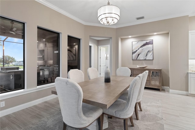 209 Pine Lilly Ct, Lake Alfred, FL 33850 - dining room featuring a chandelier, ornamental molding, light wood-style flooring, and baseboards