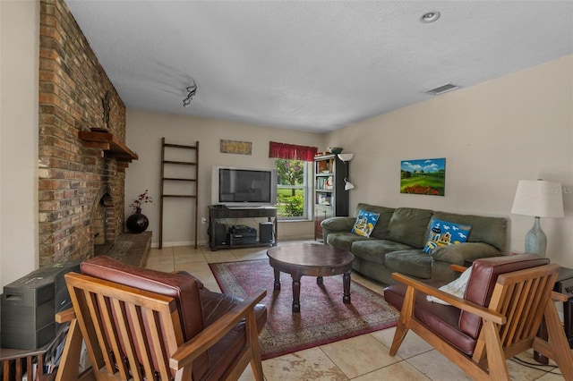 1256 Center St, Dundee, FL 33838 - living room featuring light tile patterned flooring, a textured ceiling, and a brick fireplace