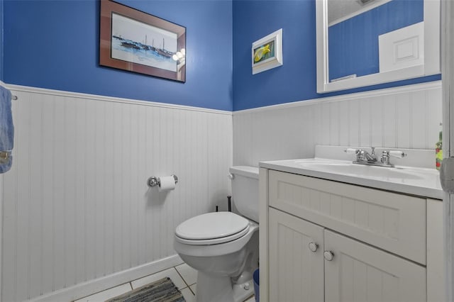 1256 Center St, Dundee, FL 33838 - half bath featuring a wainscoted wall, vanity, toilet, and tile patterned floors