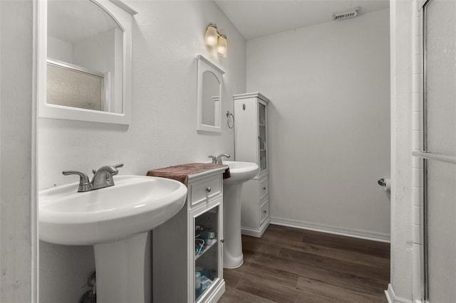 1256 Center St, Dundee, FL 33838 - bathroom with wood finished floors, a shower stall, a sink, and baseboards