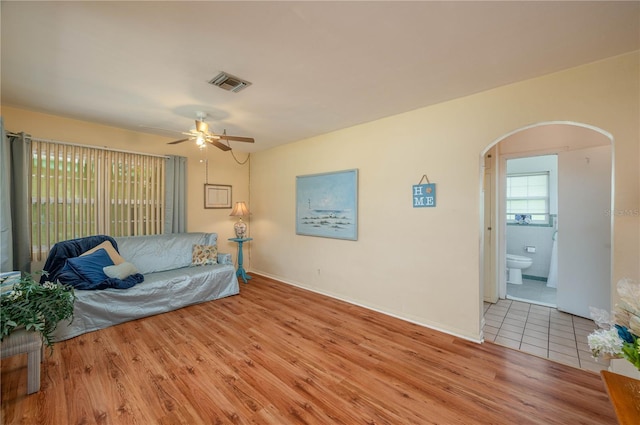 304 W Lake Ave, Auburndale, FL 33823 - living room with arched walkways, wood finished floors, a ceiling fan, and baseboards