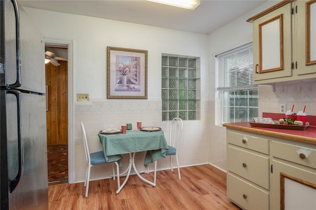 304 W Lake Ave, Auburndale, FL 33823 - dining space featuring wainscoting, tile walls, light wood-type flooring, and ceiling fan