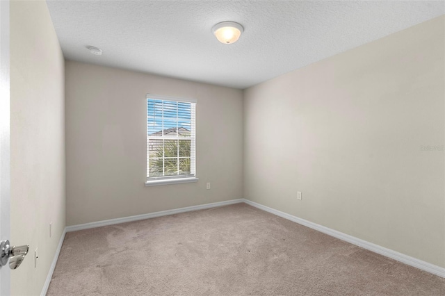 7247 Oakmoss Loop, Davenport, FL 33837 - empty room featuring light carpet, baseboards, a textured ceiling, and a smoke detector