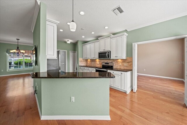 4254 Berwick Dr, Lake Wales, FL 33859 - kitchen with stainless steel appliances, a chandelier, crown molding, decorative backsplash, and decorative light fixtures