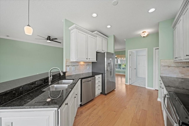 4254 Berwick Dr, Lake Wales, FL 33859 - kitchen featuring appliances with stainless steel finishes, tasteful backsplash, white cabinets, a ceiling fan, and hanging light fixtures