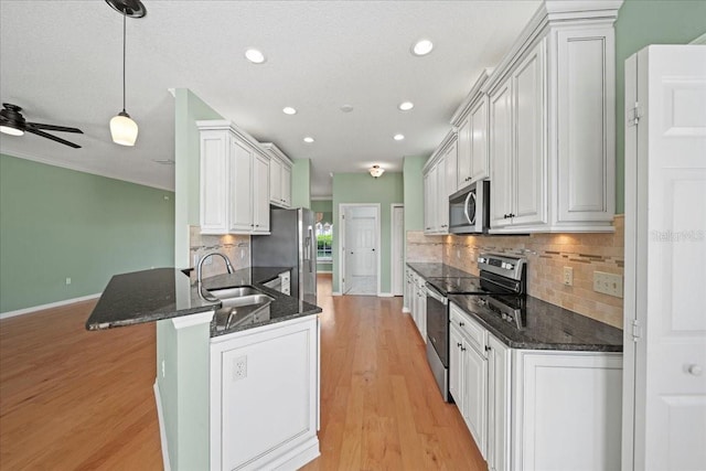 4254 Berwick Dr, Lake Wales, FL 33859 - kitchen featuring stainless steel appliances, a peninsula, decorative backsplash, recessed lighting, and light wood finished floors
