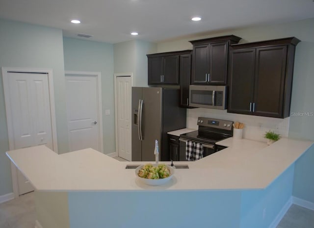 3023 Caneel, Winter Haven, FL 33884 - kitchen with stainless steel appliances, a sink, light countertops, baseboards, and a peninsula