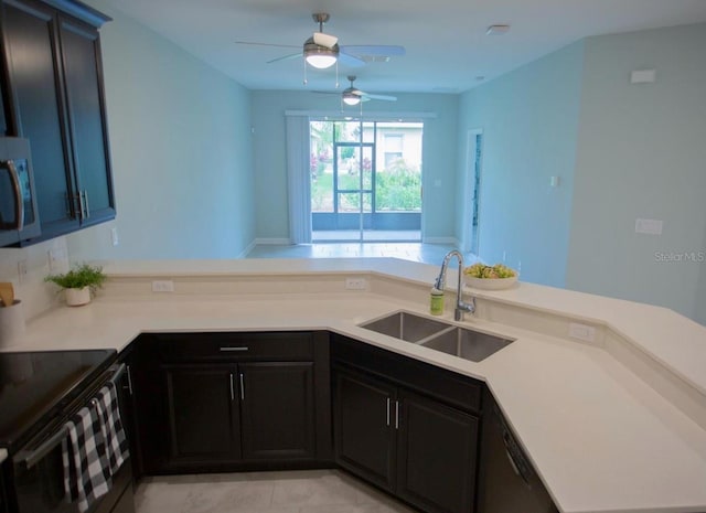 3023 Caneel, Winter Haven, FL 33884 - kitchen featuring a sink, stainless steel microwave, a ceiling fan, a peninsula, and light countertops