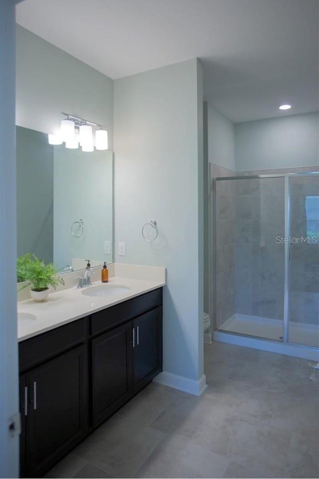 3023 Caneel, Winter Haven, FL 33884 - full bathroom with double vanity, a shower stall, tile patterned flooring, baseboards, and toilet