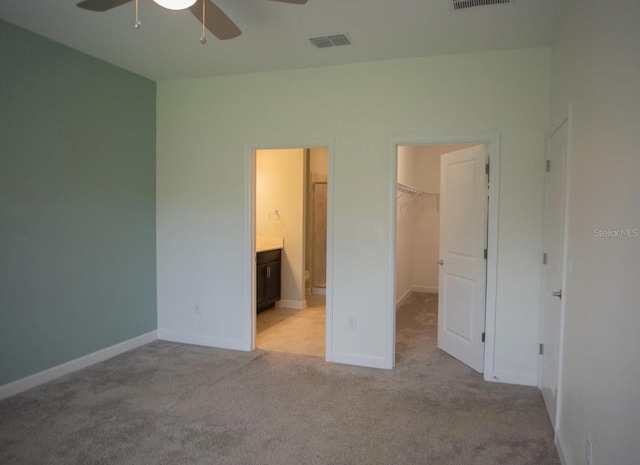 3023 Caneel, Winter Haven, FL 33884 - unfurnished bedroom with a walk in closet, light carpet, a closet, connected bathroom, and baseboards