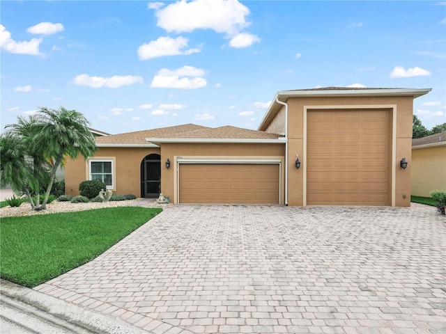 3802 Litchfield Loop, Lake Wales, FL 33859 - view of front of property featuring a garage, stucco siding, decorative driveway, and a front yard