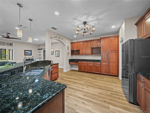 3802 Litchfield Loop, Lake Wales, FL 33859 - kitchen with freestanding refrigerator, light wood-type flooring, arched walkways, recessed lighting, and a chandelier