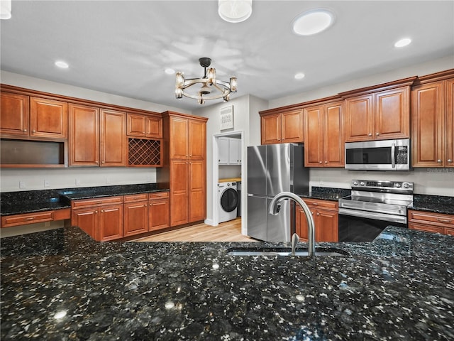 3802 Litchfield Loop, Lake Wales, FL 33859 - kitchen with appliances with stainless steel finishes, washer / clothes dryer, a chandelier, recessed lighting, and brown cabinetry