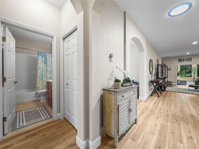 3802 Litchfield Loop, Lake Wales, FL 33859 - corridor featuring light wood-style floors, arched walkways, recessed lighting, and a textured wall